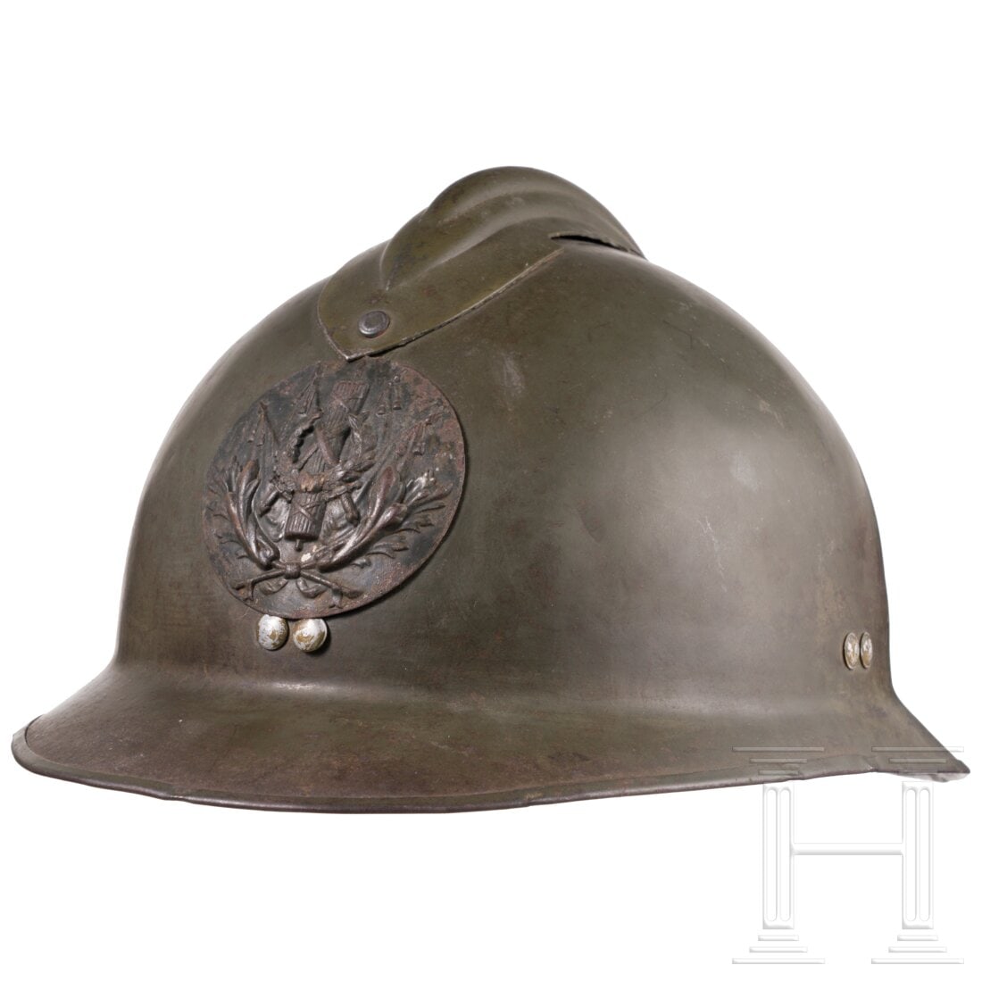 A helmet M 26 "Adrian" for members of the intendance: A helmet M 26 "Adrian" for members of the intendanceOlivgrün lackierte Metallglocke mit eiserner Randeinfassung und Verstärkungskamm sowie vs. aufgelegtem Emblem. Dunkles Lederlaschenfutter mit Schw