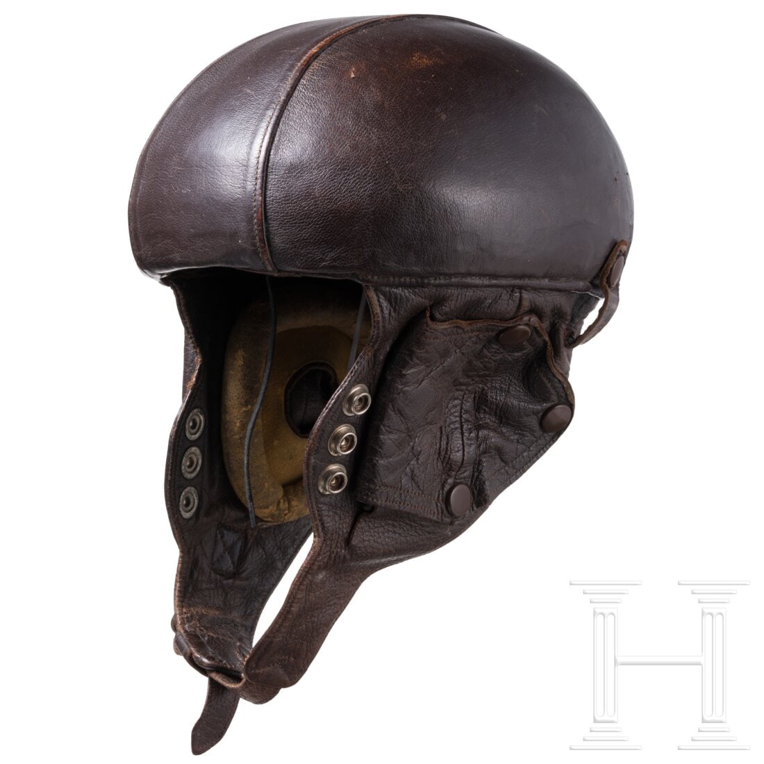 A Flying Helmet "Airaile" Type 15,1930s: A Flying Helmet "Airaile" Type 15,1930sLeichte, mit braunem Leder bezogene Glocke mit zwei Belüftungsnieten, angesetztem Nackenschutz und Ohrenklappen. Braunes Laschenfutter, im Scheitel Pariser Hers