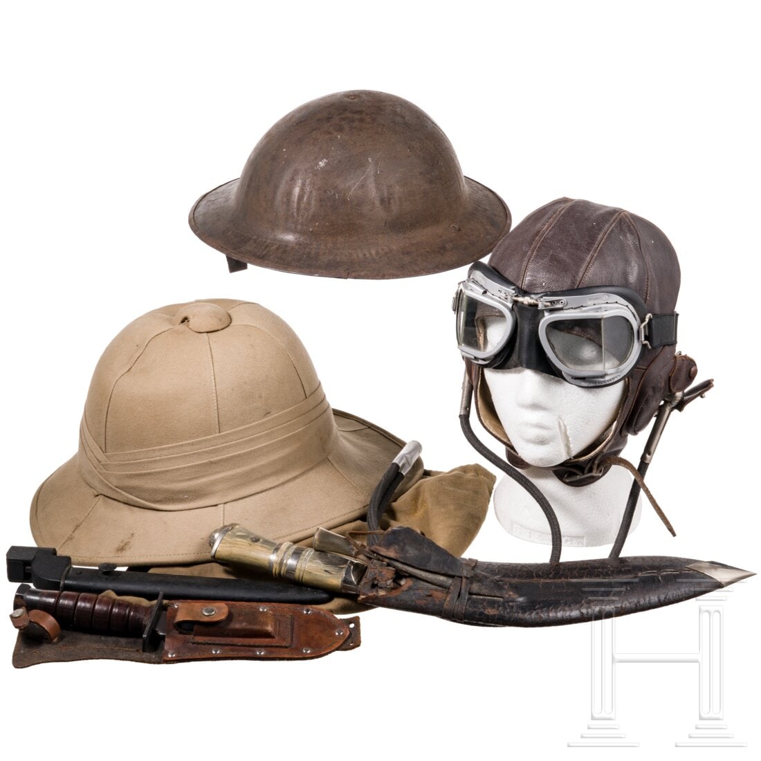 A small group of militaria: A small group of militariaEin Tropenhelm (innen zusätzlich mit Aluminiumfolie gepolstert) mit Aufbewahrungstasche, ein Brodie-Stahlhelm ohne Futter, eine Lederkopfhaube für Piloten mit Schutzbrille,