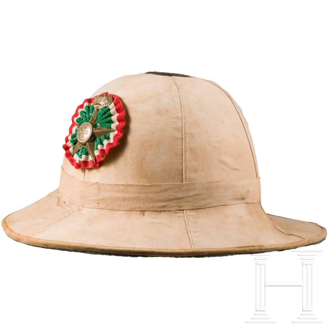 A tropical helmet M1928 for members of the medical corps: A tropical helmet M1928 for members of the medical corpsKorkkorpus mit sandfarbenem Leinenbezug, Vs. gefältete Kokarde in den Landesfarben mit aufgelegten Emblem Rot Kreuz Emblem. Sichtlich getragen,