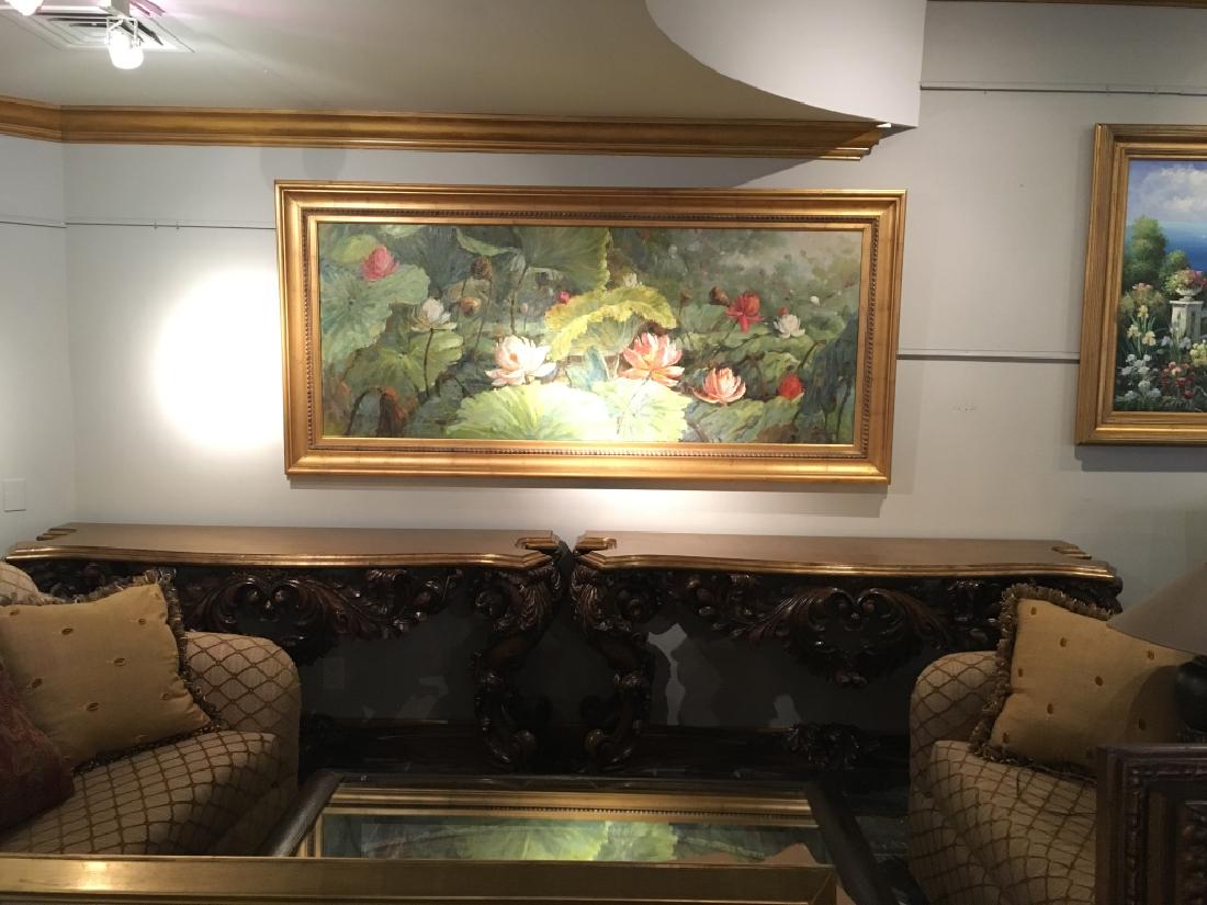 Pair of Theodore Alexander Carved Wood Consoles: A pair of Rococo carved wood serpentine console tables with gold leaf tops above leaf and scroll carved friezes on carved cabriole legs. Each table measures 35.25"H x 71"W x 24.5"D.