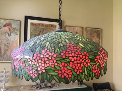 HANDEL SIGNED FLORAL STAINED GLASS CHANDELIER: The shade is artistically crafted with clusters of bright pink flowers and brilliant hues of green. Appraised in 1980 by Barry Friedman, Ltd. This is a signed piece. In excellent condition and