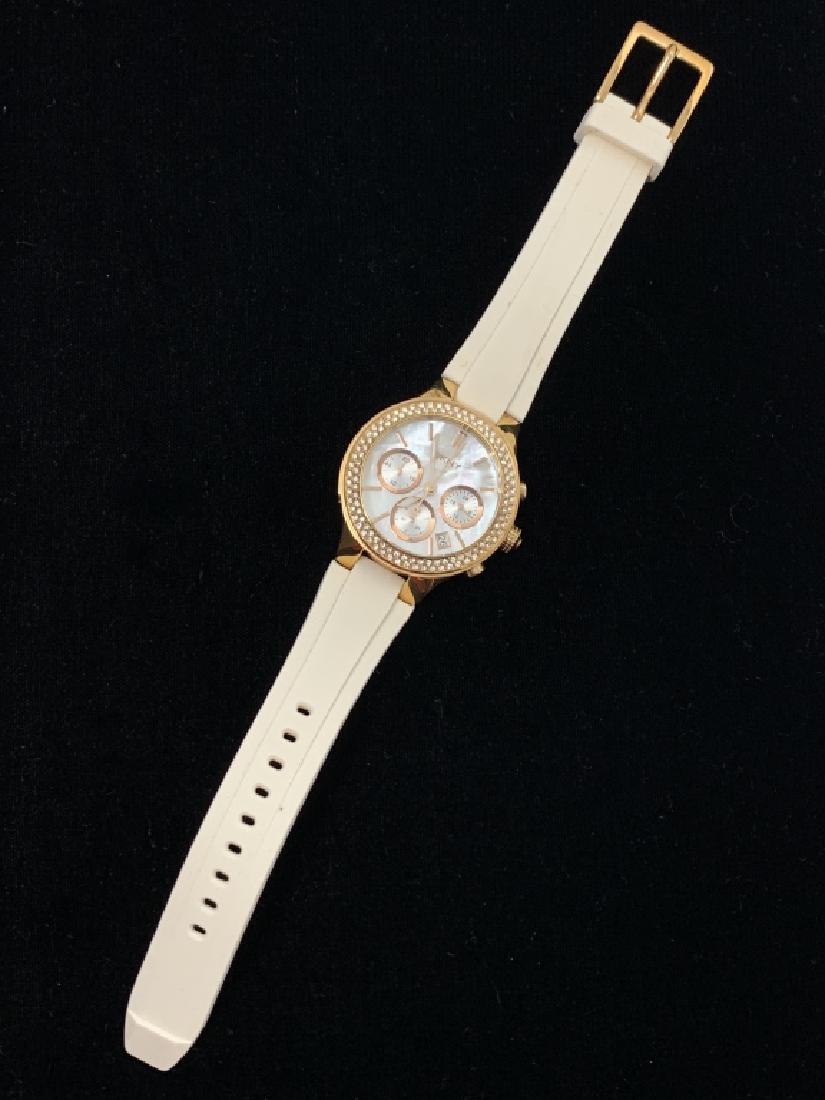 DKNY LADIES WATCH NEW IN BOX: Rose gold tone, with white plasic band . In working order . New in box with papers. Third party shipping required