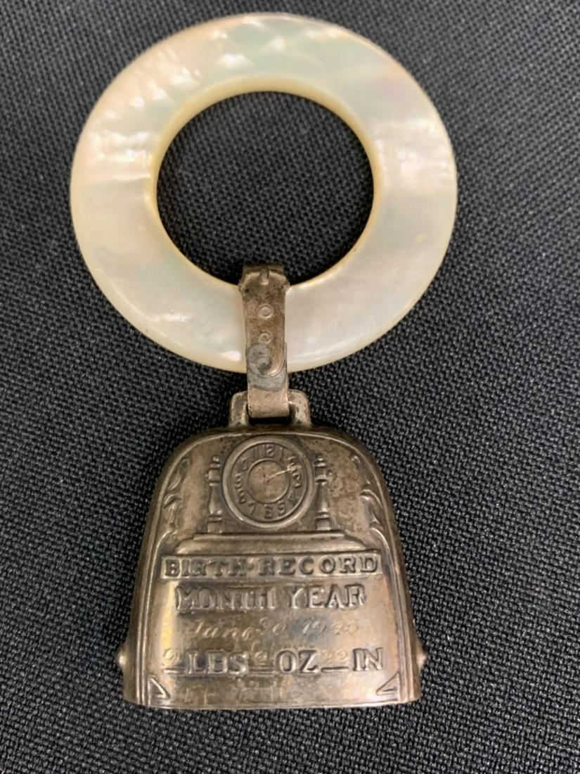 1940's BIRTH RECORD BELL MOP TEETHING RING BABY: Engraved with a birth from the 1940's, sterling silver bell attached to mother of pearl teething ring. Very popular in its era. Very good condition, about 5" long. Third party shipping required.