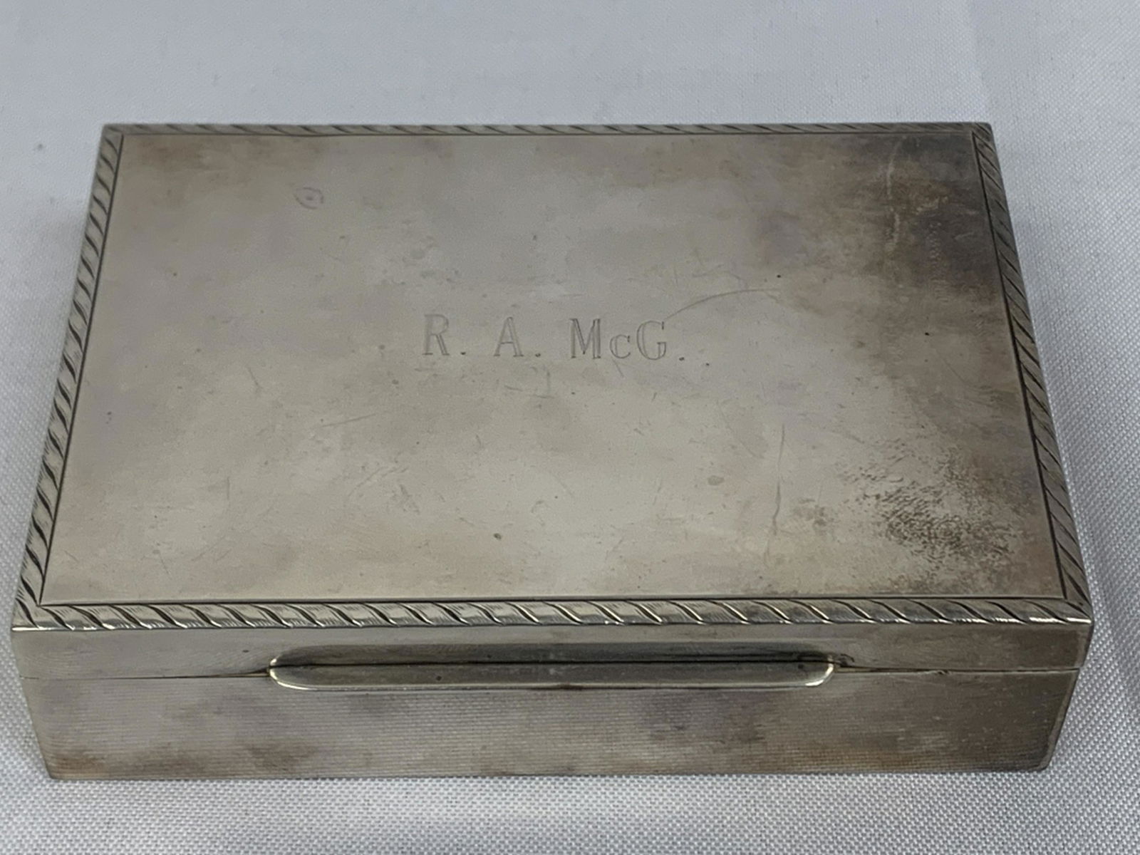 ANTIQUE STERLING SILVER BOX: Adorable and well made sterling silver box with wood lining. Engraved with "R.A. McG" Weighs 289g.measures 5" x 3 1/2" x 1 1/4"