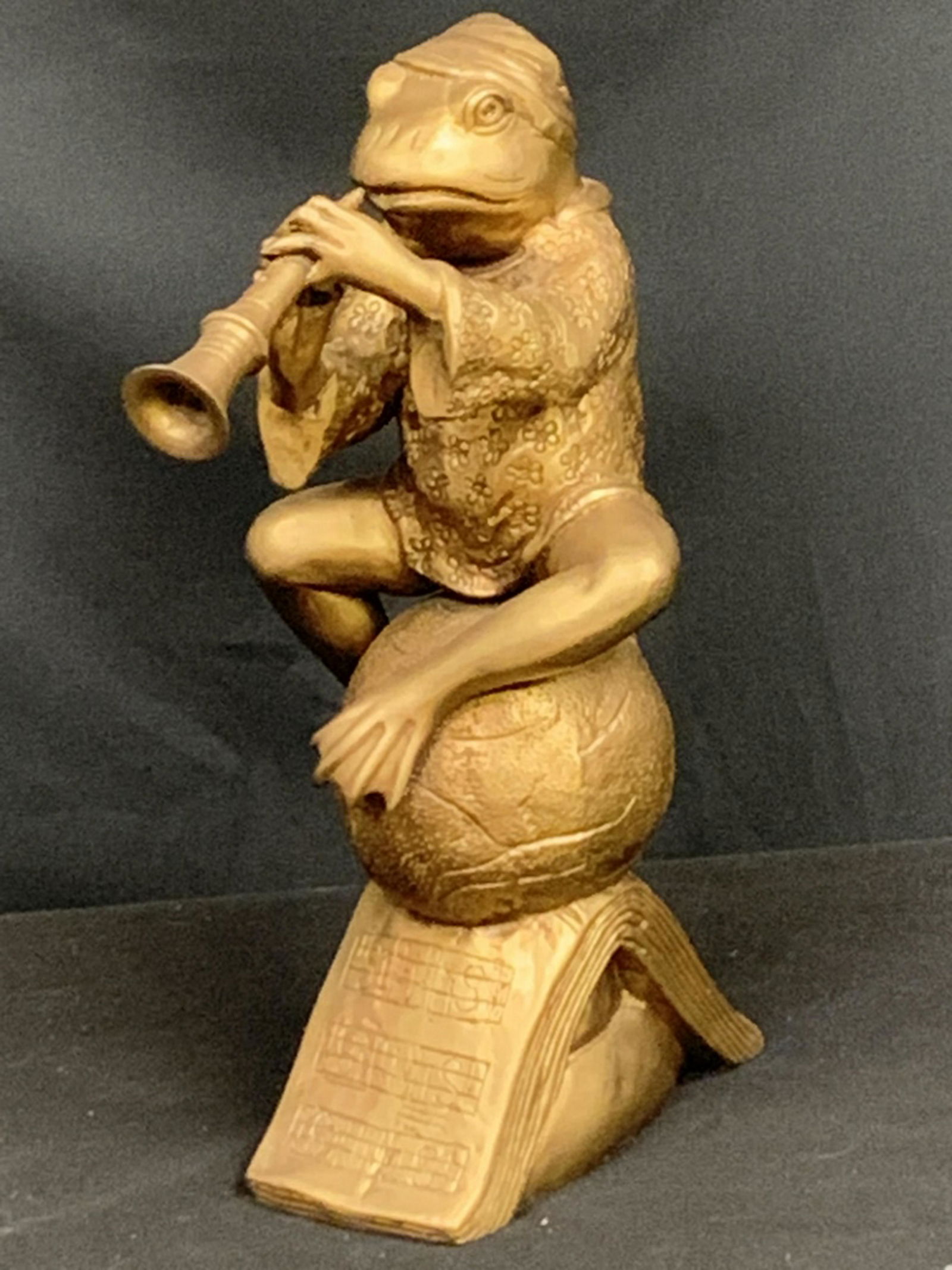 SARREID LTD HEAVY BRONZE FROG PLAYING THE FLUTE: Whimsicle frog with his nightcap on playing a trumpet. The base is etched in musical symbols and made of Indian brass. Made by SARREID LTD. About 15" high and weighs aprox. 12 lbs.