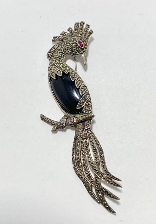 STERLING SILVER MARCASITE AND ONYX PEACOCK PIN: onyx peacock pin in sterling silver with marcasite stones and a garnet colored red eye 4 3/8" length1 1/4" width 26 grams total weight