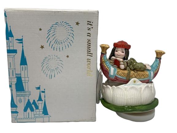 DISNEY "EGYPTIAN CLEOPATRA" MUSICAL FIGURINE: This hard to find music box features Cleopatra on a boat which is atop a lotus flower. When the music box plays "Love is a Many Splendored Thing" the entire figure rotates and the boat rocks back and 