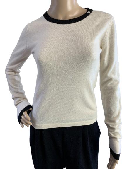 CHANEL CREAM CASHMERE BLACK TRIM RETRO SWEATER 38: CHANEL gloriously soft cashmere sweater in cream with black trim and logo detail on the collarline. Good condition. Size 38 on tag. Measures 34" bust, 22" length, 25" sleeves.