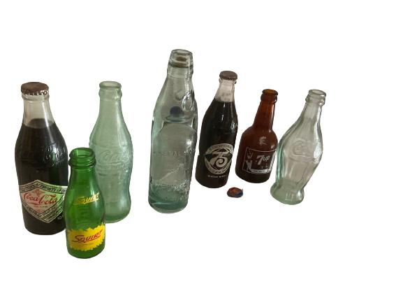 7 VINTAGE MID CENTURY SODA POP BOTTLES AND CAPS: 7 VINTAGE MID CENTURY SODA POP BOTTLES AND CAPS INCLUDING COCA COLA COMMEMORATIVE SQUIRT COKE 75 YEAR ANNIVERSARY AND 7UP COLLECTIBLE LOGO ADVERTISING RELICS HOME DECOR -B121A -DP12120