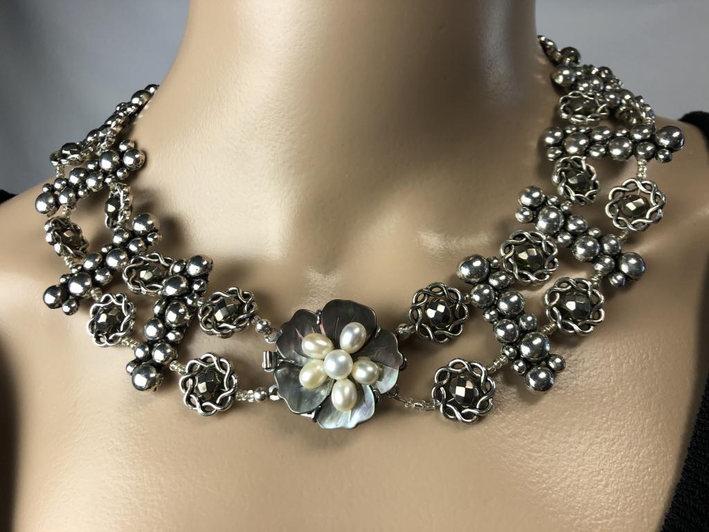 VTG SILVER CHOKER W/MOTHER OF PEARL FLOWER 8": VTG SILVER CHOKER W/MOTHER OF PEARL FLOWER 8" - TWO ROWS OF CONNECTED SILER STRANDS W/GUNMETAL STONES - FLOWER IS MOTHER OF PEARL WITH WHITE PEARL CENTER - FRONT CLOSURE - VERY GOOD VINTAGE CONDITION