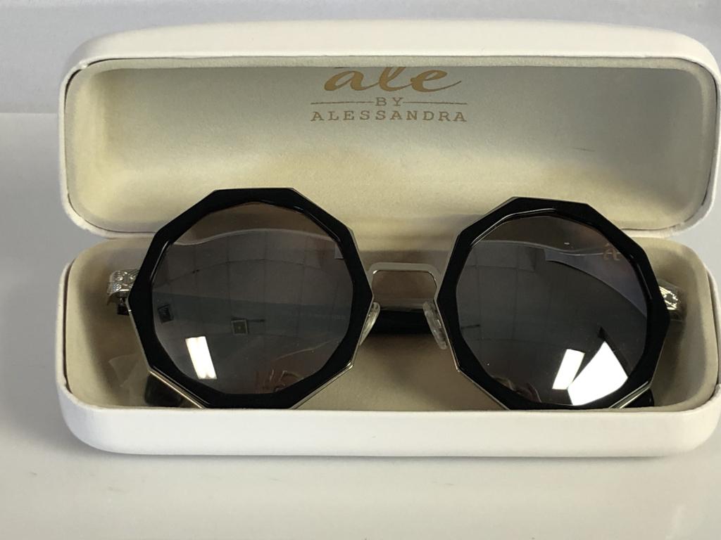 VINTAGE ALE BY ALESSANDRA SUNGLASSES IN CASE: VINTAGE ALE BY ALESSANDRA SUNGLASSES IN CASE - TEN-SIDED BLACK FRAMES AND LENSES- SILVER ACCENTS ON ARMS- INCLUDES CASE AND CLEANING CLOTH- VERY GOOD VINTAGE CONDITION