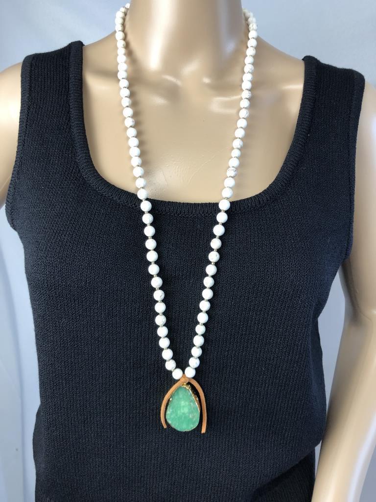 VTG LOVE AFFECTS BEADS W/GREEN AGATE PENDANT 36": VTG LOVE AFFECTS BEADS W/GREEN AGATE PENDANT 36"- DROP IS 18" - WHITE BEADS WITH GOLD STATIONS- STONE PENDANT IS SET IN GOLD AND ATTACHED WITH LEATHER- GOOD VINTAGE CONDITION