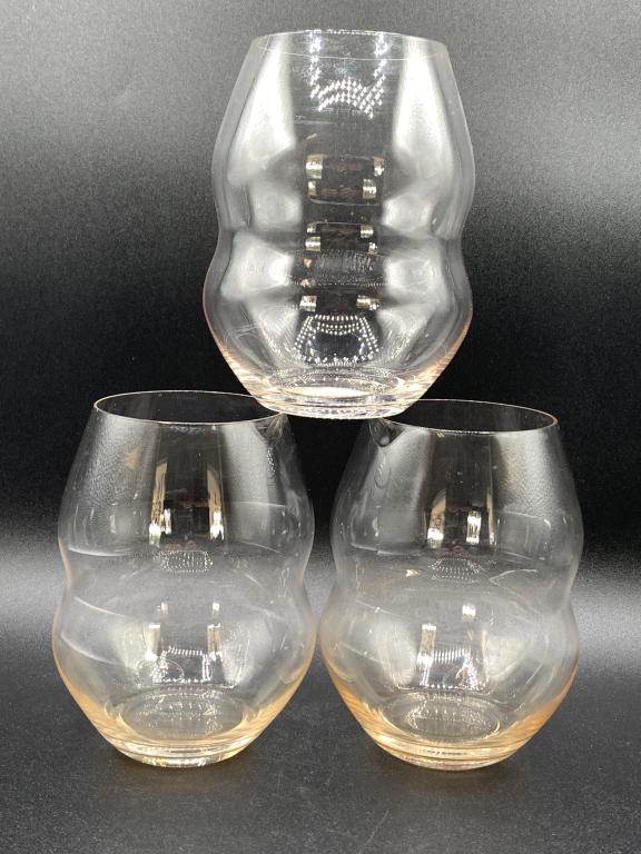 RIEDEL SWIRL STEMLESS RED WINE GLASSES SET/3: RIEDEL SWIRL STEMLESS RED WINE GLASSES SET/3 - 4.72" HIGH, 20.46 OZ CAPACITY- AMBER COLORED TINT AT BASE- DESIGNED IN 2010- MAKERS MARK ON BASE- GOOD CONDITIONCOLLECTIBLE HOME GOODS; LUXURY SERVEWARE;