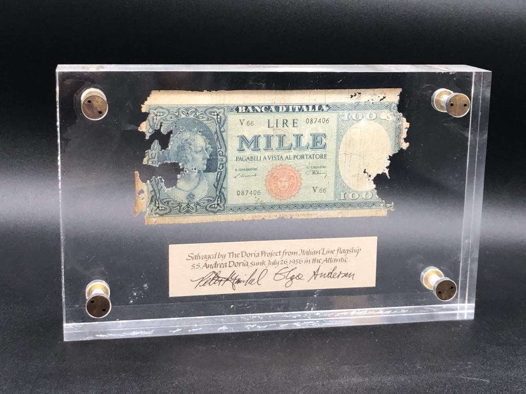 VTG FRAME 1000 ITALIAN LIRE FROM THE ANDREA DORIA: VTG FRAME 1000 ITALIAN LIRE FROM THE SS ANDREA DORIA - SALVAGED BY THE DORIA PROJECT TO COMMEMORATE THE SINKING OF THE SHIP IN 1956- LIRE & SIGNED NOTATION IS FRAMED IN HEAVY LUCITY FRAME- SOME SCRATC