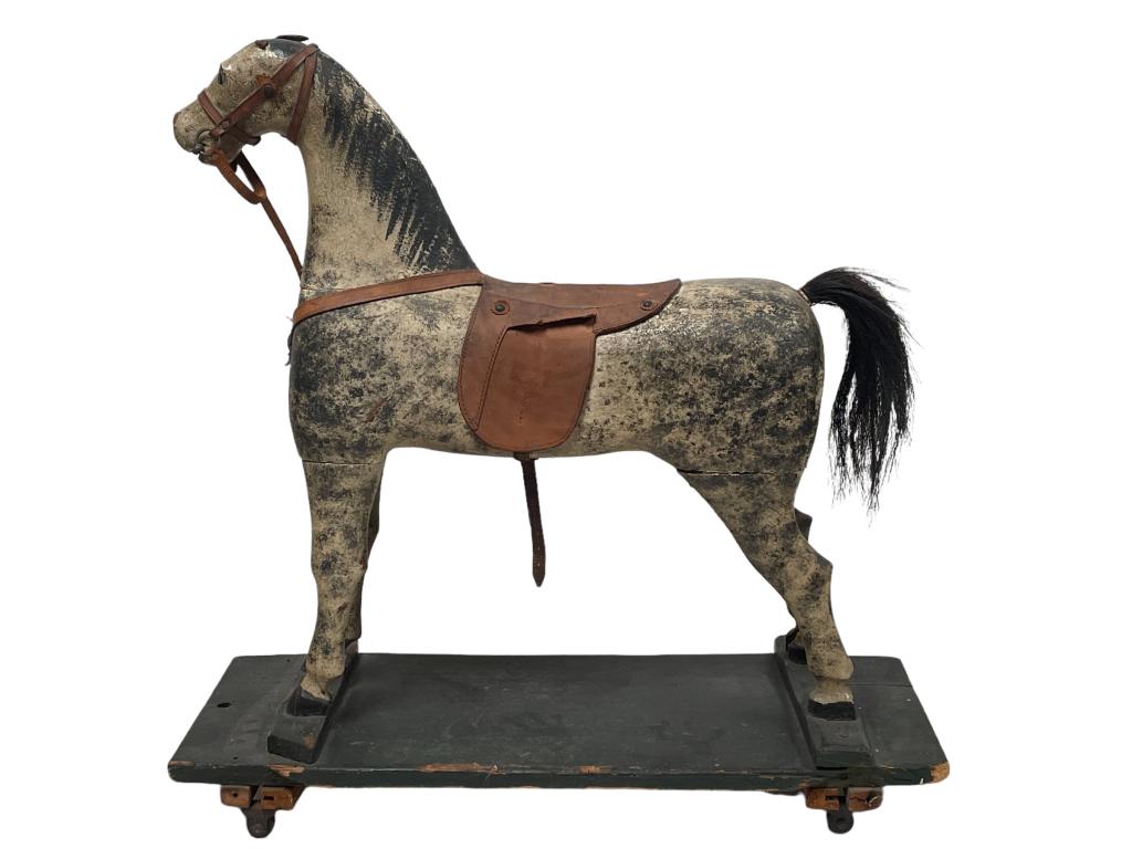 ANTIQUE WOODEN FOLK ART HOBBY HORSE ON WHEELS 31": ANTIQUE WOODEN FOLK ART HOBBY HORSE ON WHEELS WITH LEATHER SADDLE -31" X 30" X 11" APPROX-PRE OWNED CONDITION, WEAR, STRESS CRACKS, CHIPS TO WOOD-DP7622 THIRD PARTY SHIPPING REQUIRED ON ALL ITEMS. A l