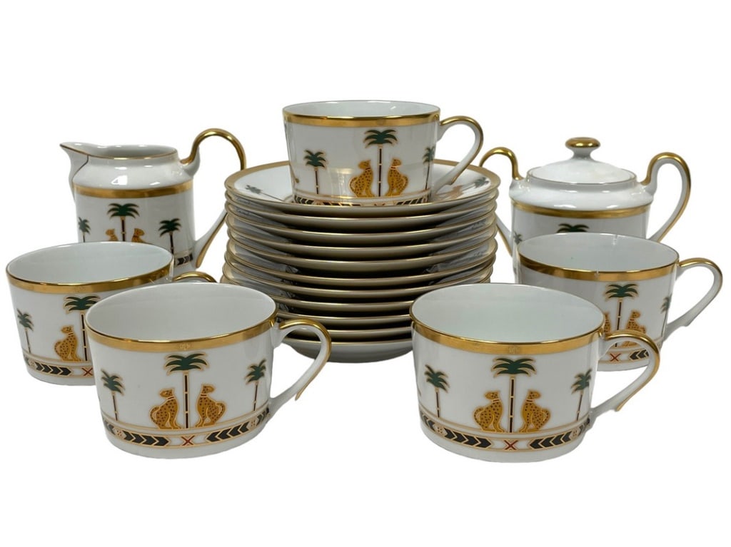22 PC CHRISTIAN DIOR CASABLANCA BONE CHINA TEA SET: CHRISTIAN DIOR CASABLANCA BONE CHINA TEA CUP & SAUCER SET WITH LEOPARDS AND PALM TREES WITH GOLD TRIMWITH CREAMER AND SUGAR CADDY-11 SAUCERS-9 CUPS-1 SUGAR-1 CREAMER-GOOD PRE OWNED CONDITION, CRACK TO