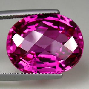 27.35 CT DEEP PINK SAPPHIRE GEMSTONE: SAPPHIRE Color: Deep Pink Size: 16.0mm x 19.50mm Weight: 27.35 cts. / 9 Shape: Oval Checkerboard Cut Clarity: IF Luster: Excellent Origin: Switzerland Condition: New Treatment: Lab Grown