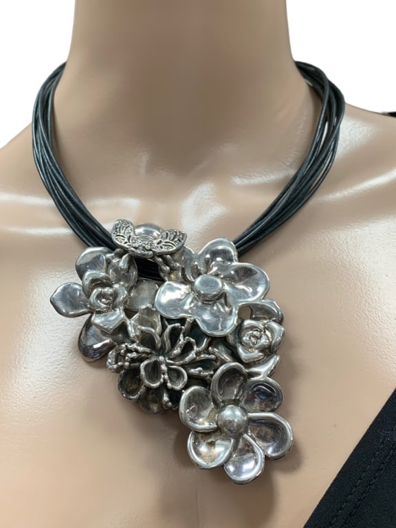 STERLING SILVER FLORAL CORDED NECKLACE: STERLING SILVER FLORAL CORDED NECKLACE -MADE IN ISRAEL 925 STERLING SILVER -SHORT BLACK CORDED NECKLACE -FLOWER AND BEE DETAILS -GOOD PRE OWNED CONDITION Bidders may pick up their items from the aucti