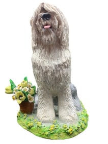 SHEEPDOG STANDING IN A FIELD OF FLOWERS