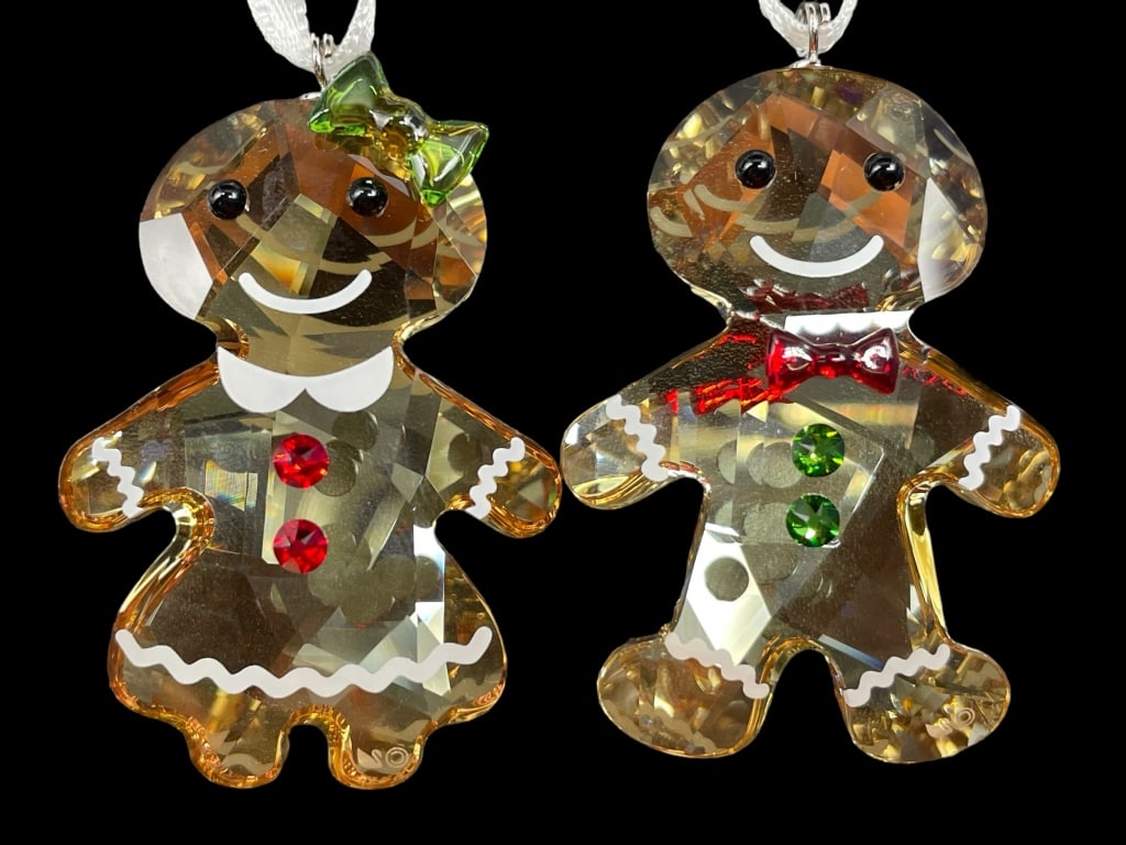 SWAROVSKI GINGERBREAD COUPLE ORNAMENT: Bring even more joy to the holiday season with this adorable Gingerbread Couple. Sparkling in a combination of festive colors with white printed details, the two characters hang on white satin ribbons