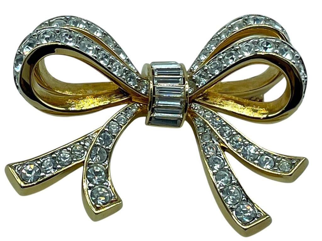 VINTAGE SWAROVSKI DOUBLE BOW BROOCH PIN: VINTAGE SWAROVSKI DOUBLE BOW BROOCH PIN -COMES WITH DUST COVER -VERY GOOD PRE OWNED CONDITION -DP102524 Bidders may pick up their items from the auction-house or have their items shipped. Some 