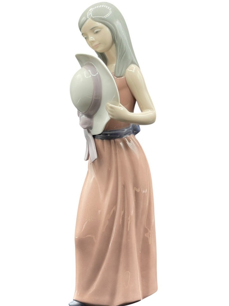 LLADRO PORCELAIN BASHFUL GIRL FIGURINE 10": LLADRO PORCELAIN BASHFUL GIRL WITH STRAW HAT FIGURINE 10" -VERY GOOD PRE OWNED CONDITION -APPROX 10" TALL -JA 121624 ***Please note that due to limited storage space, all items must be picked up withi