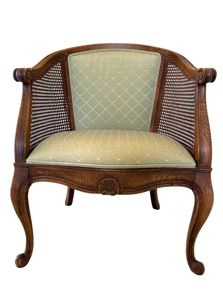 LOUIS XV-STYLE CANE BARREL CHAIR: LOUIS XV-STYLE CANE BARREL CHAIR EXUDES FRENCH ELEGANCE WITH ITS CURVED WOODEN FRAME, DELICATE CARVINGS, AND CABRIOLE LEGS. THE HANDWOVEN CANE PANELS ADD TEXTURE, WHILE THE GREEN DIAMOND-PATTERNED UPH
