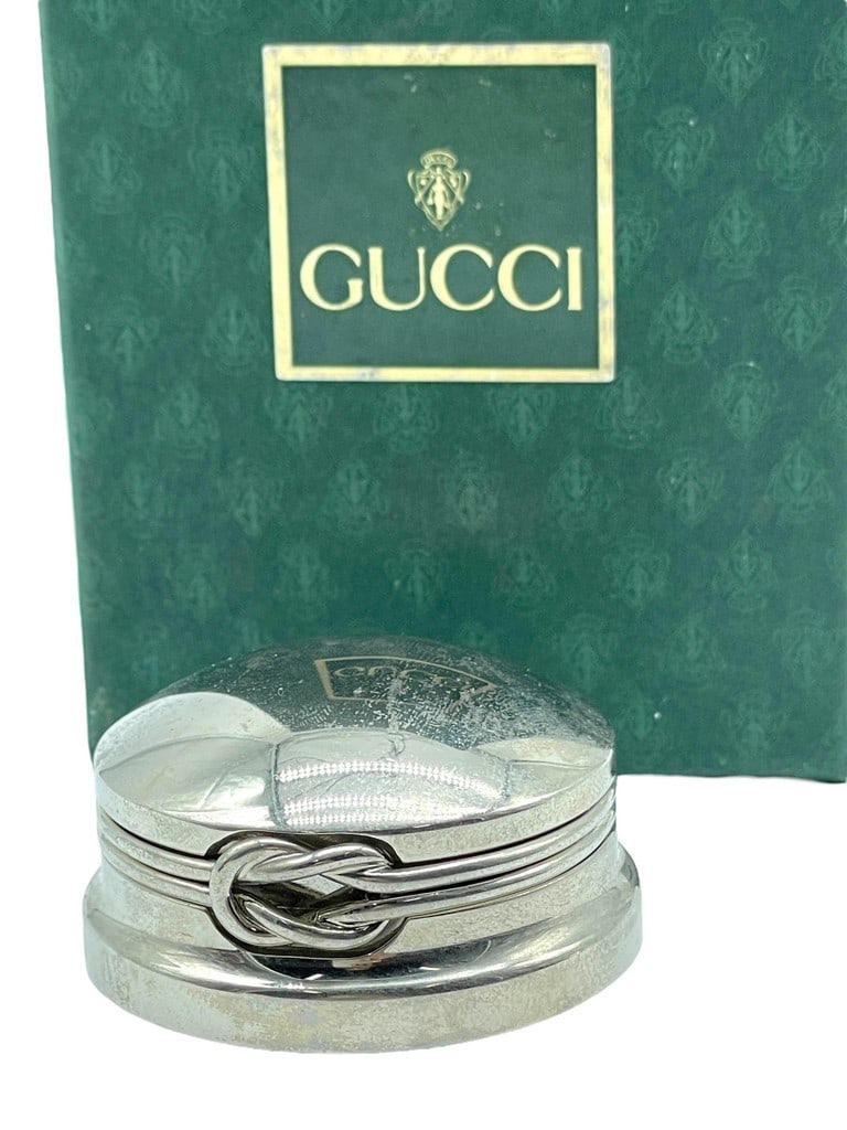 GUCCI VINTAGE SILVER ROUND WINE STOPPER: GUCCI VINTAGE SILVER ROUND WINE STOPPER -A STUNNING VINTAGE GUCCI SILVER PLATED WINE STOPPER TOP WITH A SIGNATURE INTERLOCKED KNOT DETAIL. THE ROUND DESIGN FEATURES A POLISHED FINISH WITH ELEGANT RIDG