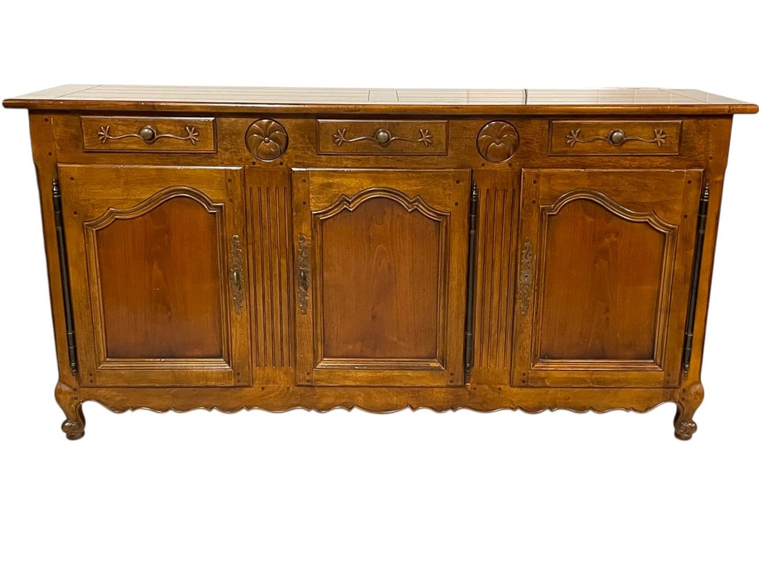 HENREDON FRENCH COUNTRY WOOD SIDEBOARD 61": HENREDON PIERRE DEUX FRENCHCOUNTRY CARVED WOOD SIDEBOARD -A BEAUTIFULLY CRAFTED FRENCH PROVINCIAL SIDEBOARD FEATURING THREE DRAWERS AND TWO CABINET DOORS WITH ORNATE CARVINGS. THE WARM WOOD TONES, FLU