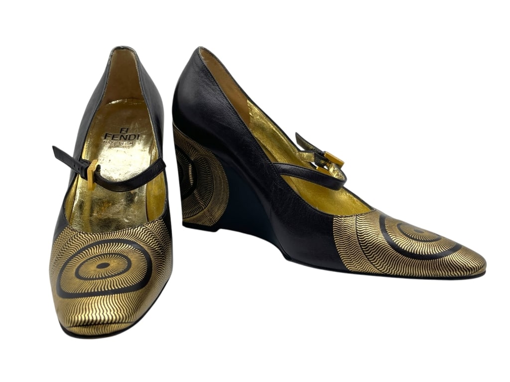 FENDI BLACK & GOLD LEATHER MARY JANE WEDGE HEELS: FENDI BLACK & GOLD LEATHER MARY JANE WEDGE HEELS -VERY GOOD PRE OWNED CONDITION -SIZE 36.5 -FENDI BLACK AND GOLD LEATHER MARY JANE WEDGE HEELS WITH STRIKING CIRCULAR DESIGN AND METALLIC INTERIOR, MADE