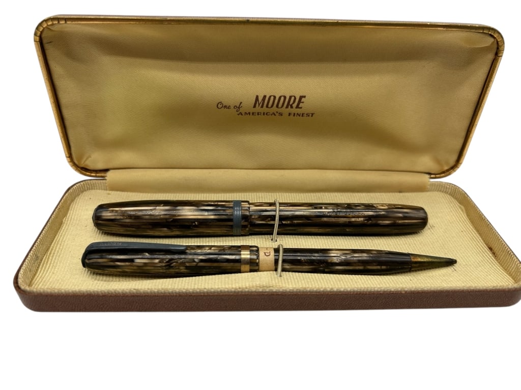 VINTAGE MOORE FOUNTAIN PEN & PENCIL SET: - VINTAGE MOORE FOUNTAIN PEN & PENCIL SET – MARBLED BROWN WITH GOLD TRIM – IN ORIGINAL CASE. - PREOWNED VINTAGE WEAR CONSISTENT WITH AGE -UNTESTED FOR FUNCTIONALITY. - MS 040725 - By bidding on th