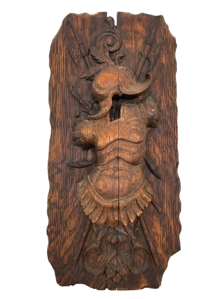 HAND-CARVED WOOD PANEL FEATURING ARMOR 15": HAND-CARVED WOOD PANEL FEATURING ARMOR, HELMET, AND SHIELD MOTIF 15" -VERY GOOD PRE OWNED CONDITION -APPROX 15" X 7" -INTRICATE DETAILING WITH SCROLL AND SPEAR ACCENTS. RICH PATINA AND RUSTIC TEXTURE.