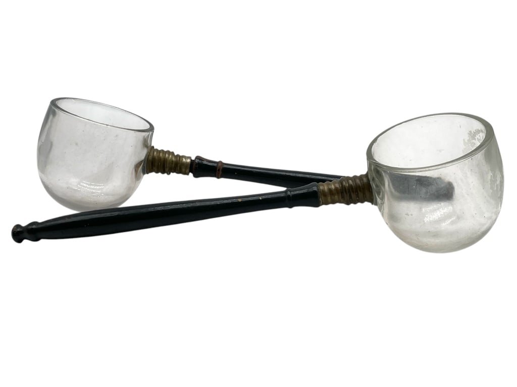 PAIR OF VINTAGE GLASS DIPPERS/LADLES 14": PAIR OF VINTAGE GLASS DIPPERS/LADLES 14" -GOOD PRE OWNED CONDITION, WEAR FROM AGE -APPROX 14" -FEATURING HAND-BLOWN CLEAR GLASS BOWLS WITH TURNED BLACK WOOD HANDLES AND BRASS COLLARS -JA 041825 By bid