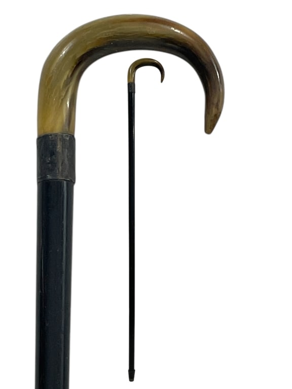 WALKING CANE WITH POLISHED HORN HANDLE 34": WALKING CANE WITH POLISHED HORN HANDLE 34" -VERY GOOD PRE OWNED CONDITION -APPROX 34" -CLASSIC CROOKED HANDLE DESIGN MOUNTED ON A SLEEK BLACK SHAFT. FINISHED WITH METAL COLLAR AND RUBBER TIP. A TIMELE