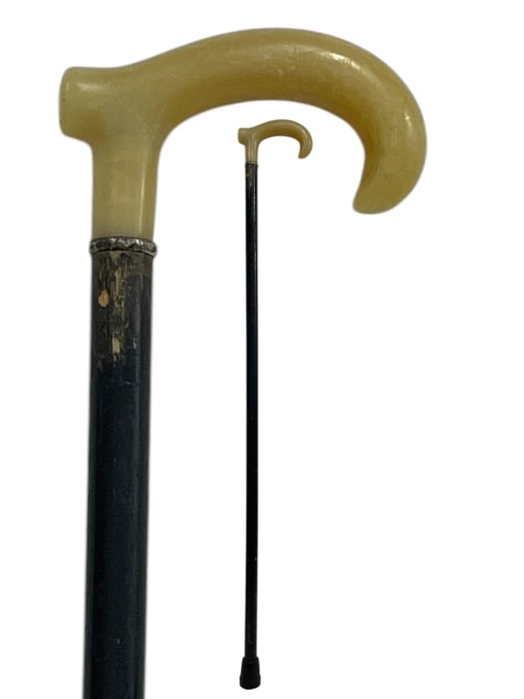 WALKING CANE WITH CREAM COLORED CROOK HANDLE 35": GENTLEMAN'S WALKING CANE WITH CREAM COLORED CROOK HANDLE 35" -GOOD PRE OWNED CONDITION, WEAR ON HANDLE FROM USE -APPROX 35" -CLASSIC DESIGN FEATURING A RICH BLACK SHAFT AND DECORATIVE METAL COLLAR. FI
