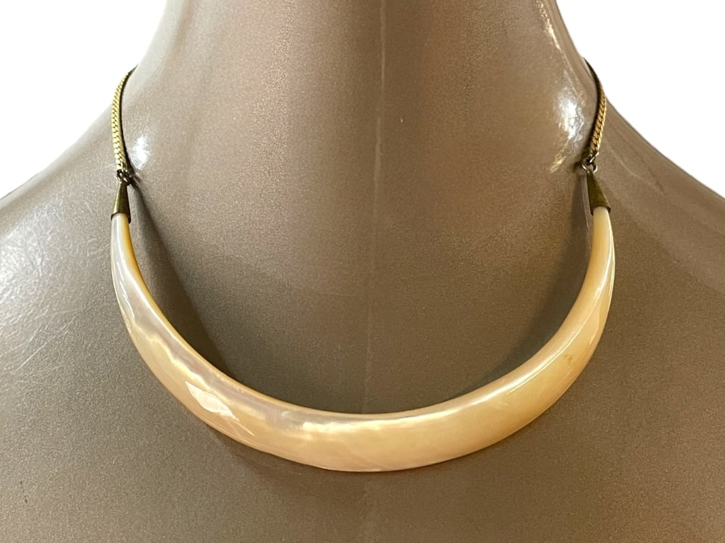 LES BERNARD INC. CURVED LUCITE STATEMENT NECKLACE: LES BERNARD INC. CURVED LUCITE STATEMENT NECKLACE -VERY GOOD PRE OWNED CONDITION -APPROX 7.5" -LUCITE STATEMENT NECKLACE WITH BRASS-TONE METAL ENDS AND CHAIN. BOLD MINIMALIST DESIGN WITH NATURALISTIC