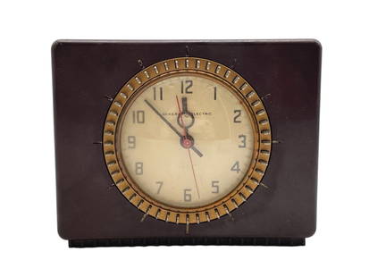 GENERAL ELECTRIC BAKELITE CLOCK: GENERAL ELECTRIC BAKELITE CLOCK -VERY GOOD PRE OWNED CONDITION -CLASSIC MID-CENTURY DESIGN WITH BRASS-TONE ACCENTS AND CREAM DIAL. UNTESTED -JA 042425 By bidding on this item, you have read, understan