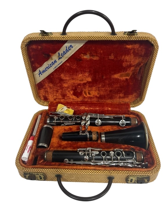 VINTAGE AMERICAN LEADER CLARINET IN ORIGINAL CASE: - A WONDERFUL COLLECTIBLE FOR MUSICIANS, VINTAGE INSTRUMENT LOVERS, OR DECORATORS LOOKING FOR A NOSTALGIC PIECE. - DISPLAYS MODERATE WEAR CONSISTENT WITH AGE, IDEAL FOR DISPLAY, RESTORATION, OR BEGINN