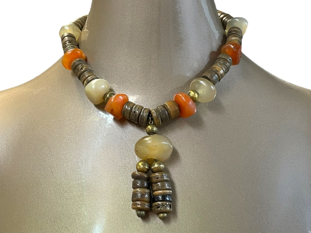 VINTAGE NECKLACE WITH CARVED STONE BEADS: VINTAGE NECKLACE WITH CARVED STONE BEADS -VERY GOOD PRE OWNED CONDITION -APPROX 10" -BEADS INTERSPERSED WITH DECORATIVE METAL SPACERS AND A DOUBLE-TIERED BEADED DROPLET PENDANT. -JA 052325