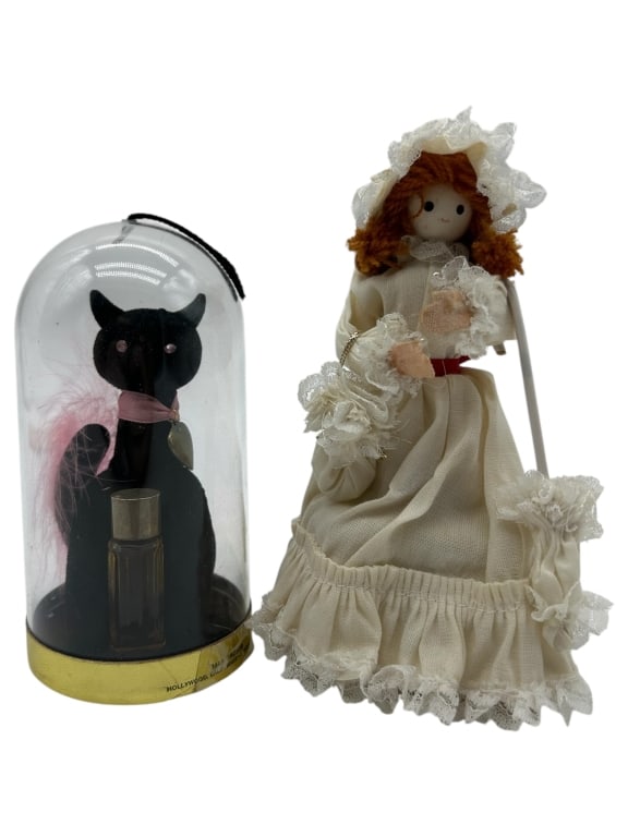 HOLLYWOOD MINIATURE & SOUTHERN BELLE FIGURINE 6": - UNIQUE DUO FEATURING A BLACK FELT CAT PERFUME BOTTLE HOUSED UNDER A CLEAR DOME, MARKED “HOLLYWOOD MINIATURES – HOLLYWOOD, CALIFORNIA,” COMPLETE WITH ORIGINAL VIAL AND PINK FEATHER ACCENT. 