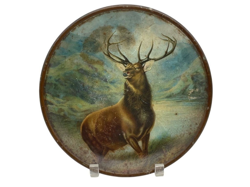 ROUND TIN LITHO TRAY FEATURING STAG 10": ROUND TIN LITHO TRAY FEATURING MAJESTIC STAG IN MOUNTAIN LANDSCAPE 10" -VERY GOOD PRE OWNED CONDITION -APPROX 10" -VIBRANT COLORS WITH VINTAGE WEAR AND PATINA. IDEAL FOR RUSTIC DECOR OR COLLECTORS OF 
