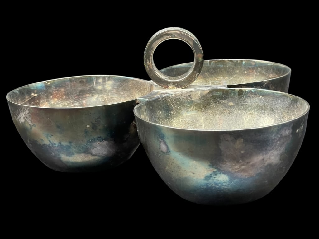 RALPH LAUREN MID MOD STYLE SERVING BOWL 8": MODERNIST MID-CENTURY STYLE TRIPLE SERVING BOWL BY RALPH LAUREN IN POLISHED METAL FINISH. FEATURES THREE CONNECTED ROUNDED BOWLS WITH A CENTRAL LOOP HANDLE, IDEAL FOR NUTS, CANDY, OR BAR SNACKS. IMPRE