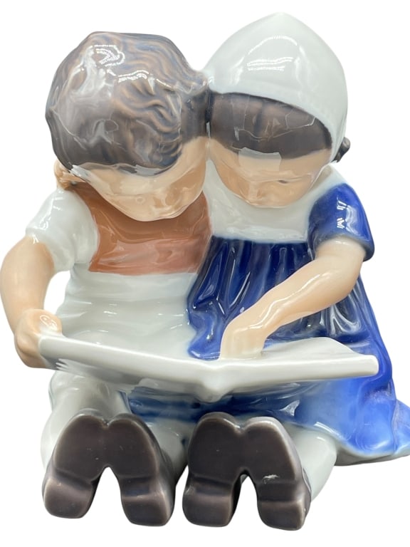 ROYAL COPENHAGEN FIGURINE: ROYAL COPENHAGEN FIGURINE #1567 – BOY AND GIRL READING BOOKVINTAGE ROYAL COPENHAGEN PORCELAIN FIGURINE MODEL #1567 FEATURING A BOY AND GIRL SEATED CLOSELY, READING A BOOK TOGETHER. HIGH-GLOSS FINISH