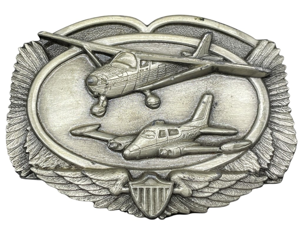 1983 SISKIYOU AVIATION AIRPLANE BELT BUCKLE: VINTAGE 1983 SISKIYOU BELT BUCKLE FEATURING TWO CLASSIC AIRPLANES IN HIGH RELIEF WITH WINGS AND SHIELD MOTIF. MADE OF SOLID PEWTER BY SISKIYOU BUCKLE CO., INC. IN WILLIAMS, OREGON. MARKED ON THE BACK