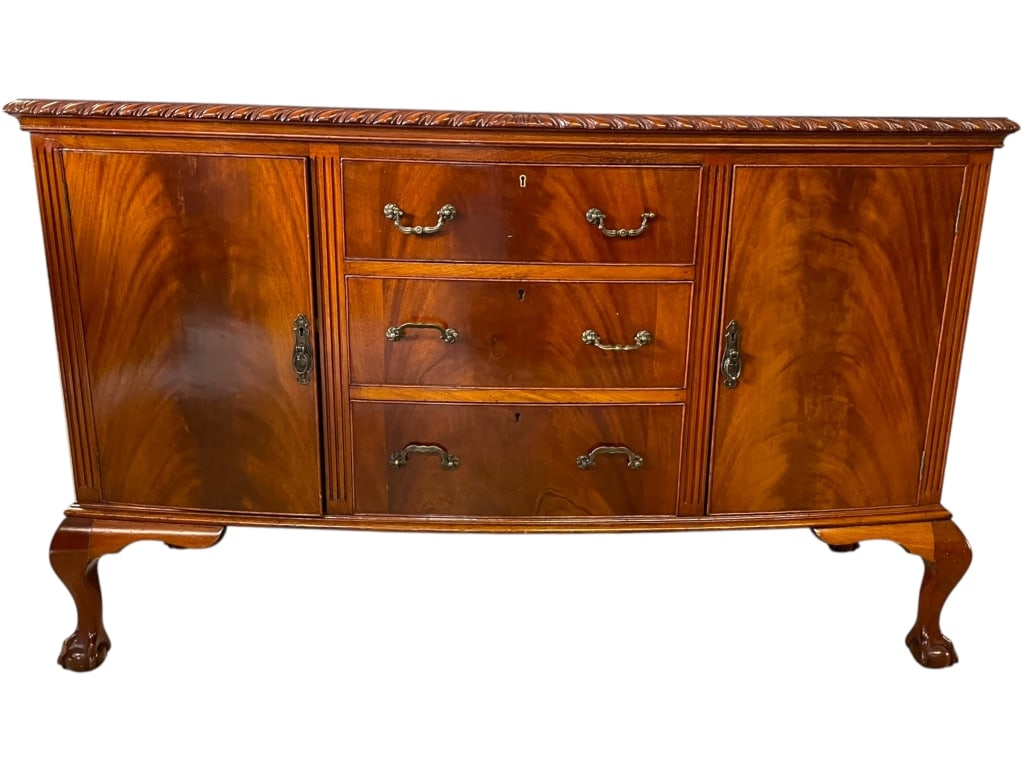 TRADITIONAL MAHOGANY BALL FOOT SIDEBOARD 59": TRADITIONAL MAHOGANY SIDEBOARD WITH CARVED DETAILS AND CABRIOLE LEGS ELEGANT VINTAGE MAHOGANY SIDEBOARD FEATURING A CARVED ROPE-EDGE TOP, THREE CENTRAL DRAWERS WITH ORIGINAL BRASS PULLS, AND TWO PANEL