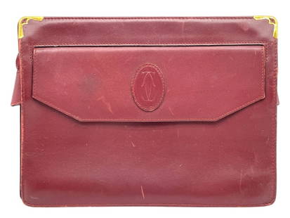 CARTIER BORDEAUX LEATHER CLUTCH BAG: CARTIER BORDEAUX LEATHER CLUTCH BAG -GOOD PRE OWNED CONDITION, SOME WEAR THROUGHOUT (SEE PHOTOS) -APPROX 10.5" X 8" -CARTIER BORDEAUX RED LEATHER DOCUMENT OR CLUTCH FOLIO FEATURING THE ICONIC EMBOSSED