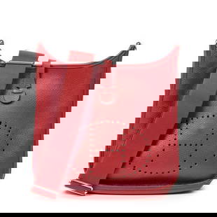 HERMÈS EVELYN PM SHOULDER BAG IN RED CLEMENCE LEA: HERMÈS EVELYN PM SHOULDER BAG IN RED CLEMENCE LEATHER WITH PALLADIUM HARDWARE – This iconic Hermès Evelyn bag is crafted from supple Clemence leather in a striking red hue, featuring the signature