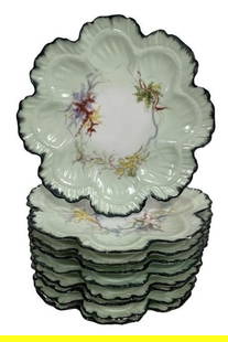 SET OF NINE D&C LIMOGES STYLE OYSTER PLATES 8.5": -PRODUCED BY DELINIERES & CO. IN LIMOGES, FRANCE, CIRCA 1894–1900 – EACH PLATE FEATURES A BEAUTIFULLY MOLDED FLORAL FORM WITH HAND-PAINTED BOTANICAL SPRAYS, FLOWING RIBBON DETAILS, AND A MINT GREE