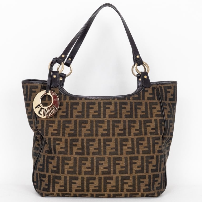 FENDI CHEF TOTE BROWN ZUCCA CANVAS SHOULDER BAG: The Fendi Chef Tote offers a refined, structured take on the brand’s signature monogram design. Crafted in Italy from brown Zucca canvas with smooth brown leather trim, it is accented by gleaming go